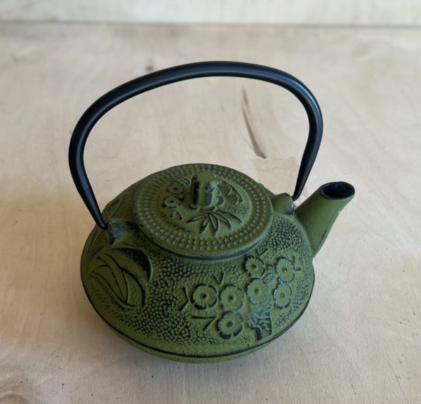 Liatinový čajník v zelenej farbe s pokrievkou a sitkom na čaj vo vnútri.