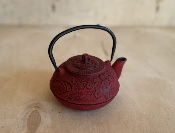 Liatinový čajník v červenej farbe so zatvorenou pokrievkou