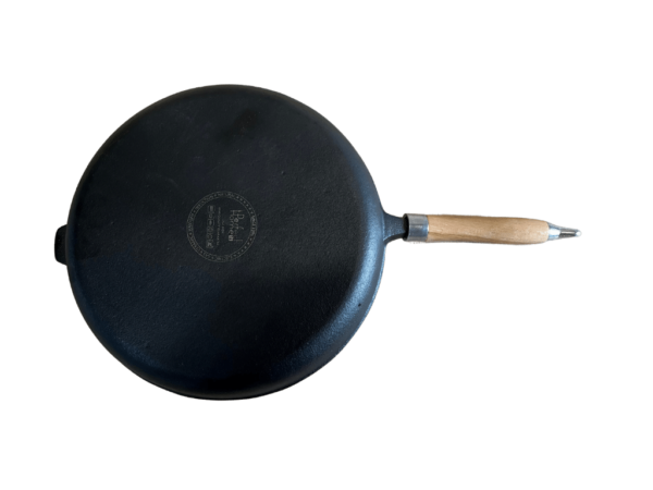 Liatinová panvica s drevenou rukoväťou zo zadnej strany